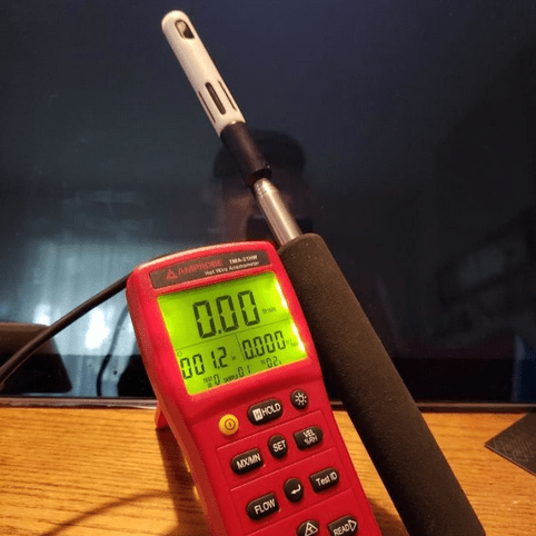 The digital display of the AMPROBE TMA-21HW anemometer with its backlight illuminated for clear visibility in low-light conditions, ready for measurement.