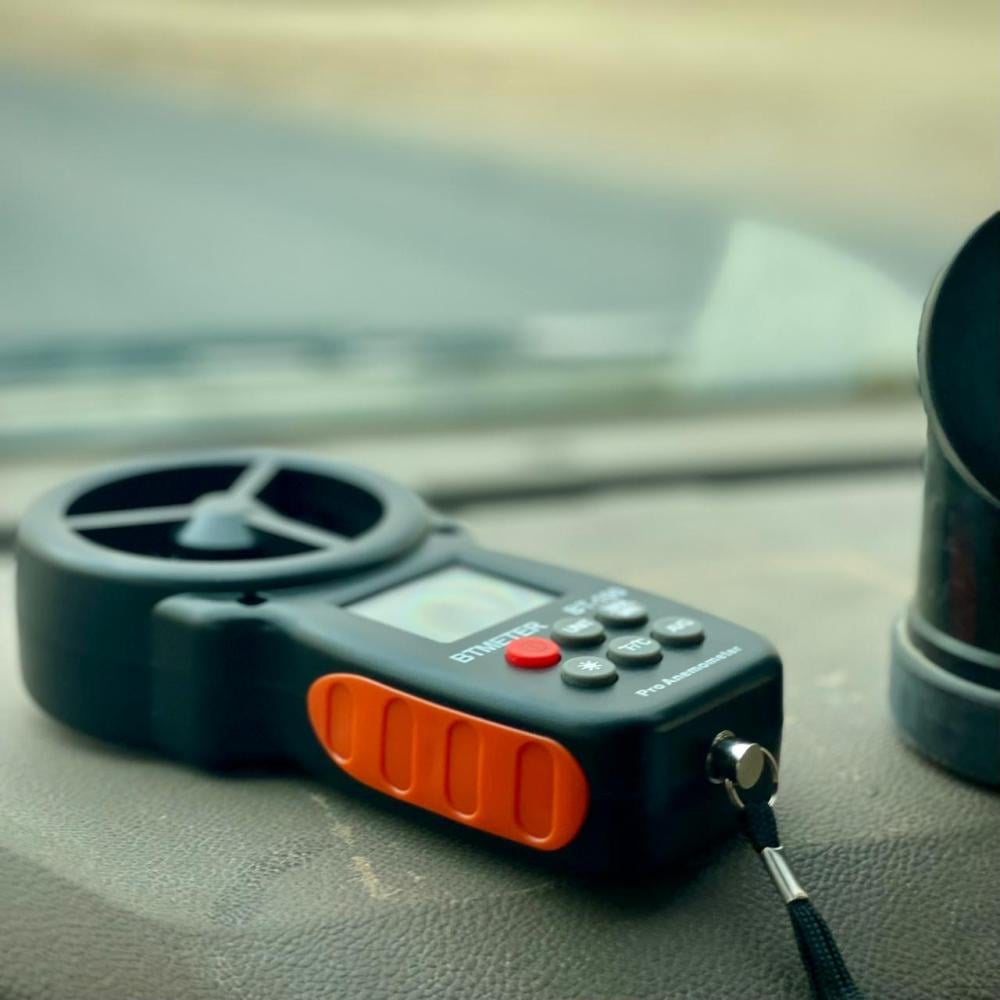 The BTMETER BT-100 portable wind speed meter placed on a vehicle dashboard, ready for outdoor use with a clear view of the environment, ideal for drone pilots and sailors in Sri Lanka.