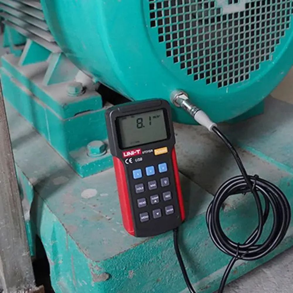 Reliability engineer measuring electric motor vibration with the UNI-T UT315A digital tester to monitor bearing health and evaluate mechanical condition.