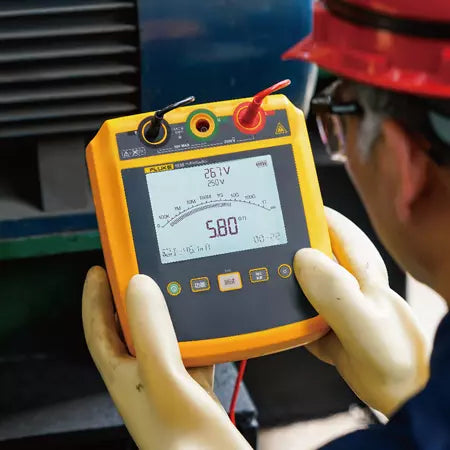 Technician using FLUKE 1537 insulation tester to measure motor winding insulation showing 5.8 gigaohm reading on 250V test range