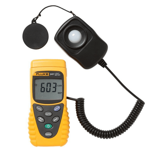 The FLUKE 941 digital lux meter showing a precise light measurement of 603 lux with the main unit, detachable probe, and protective cap visible.