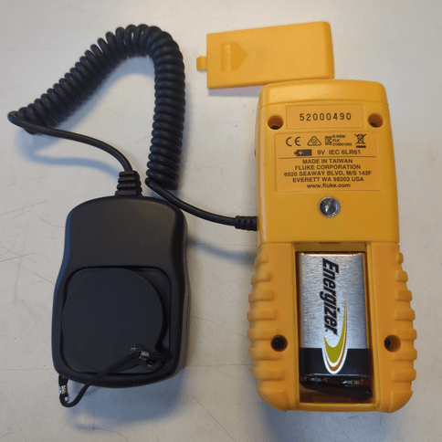 Rear view of the FLUKE 941 digital lux meter with the battery compartment open, showing the installed 9V battery and visible product serial number.