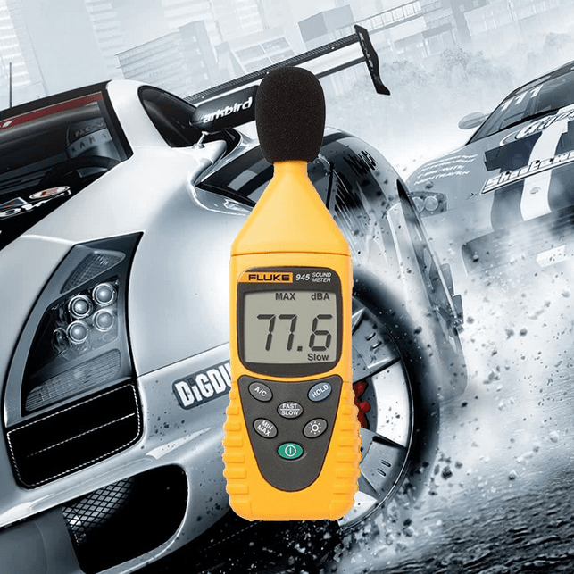 The Fluke 945 sound level meter ready for high-performance noise measurement, shown against a formula racing car background to represent speed and precision.