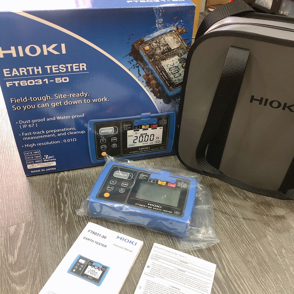 The HIOKI FT6031-50 earth tester shown with its official retail box, carrying case, user manual, and certificate.