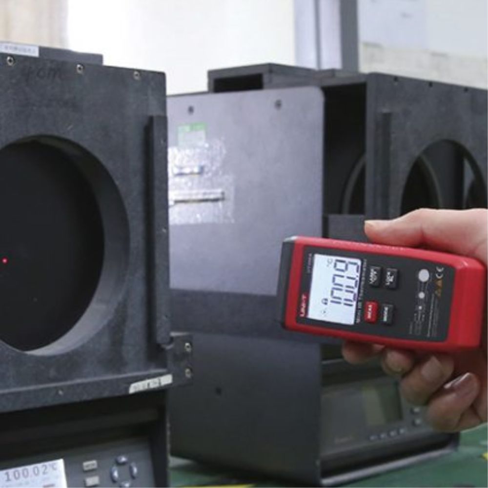 HVAC technician performing air conditioning vent and ductwork inspection using UNI-T UT306A laser thermometer to detect insulation leaks and cooling efficiency