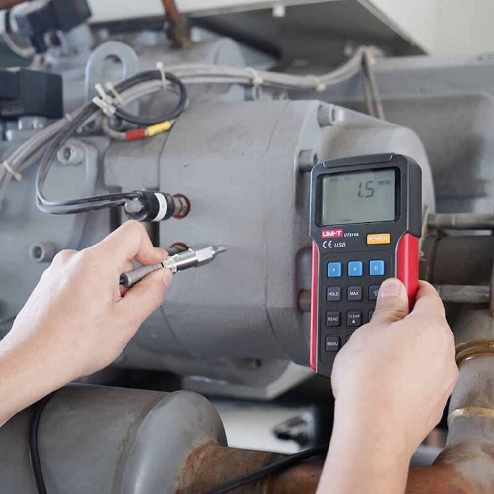 The UNI-T UT315A portable vibration meter being used for vibration analysis on an industrial power generator to detect complex structural faults.