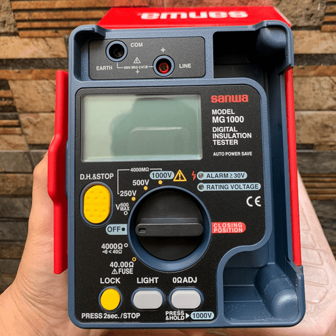 User removing SANWA MG1000 insulation tester from official retail box before connecting test leads