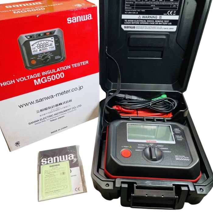Sanwa MG5000 insulation tester kit neatly arranged inside hard carrying case with test leads, user manual, calibration certificate, and retail box beside it.