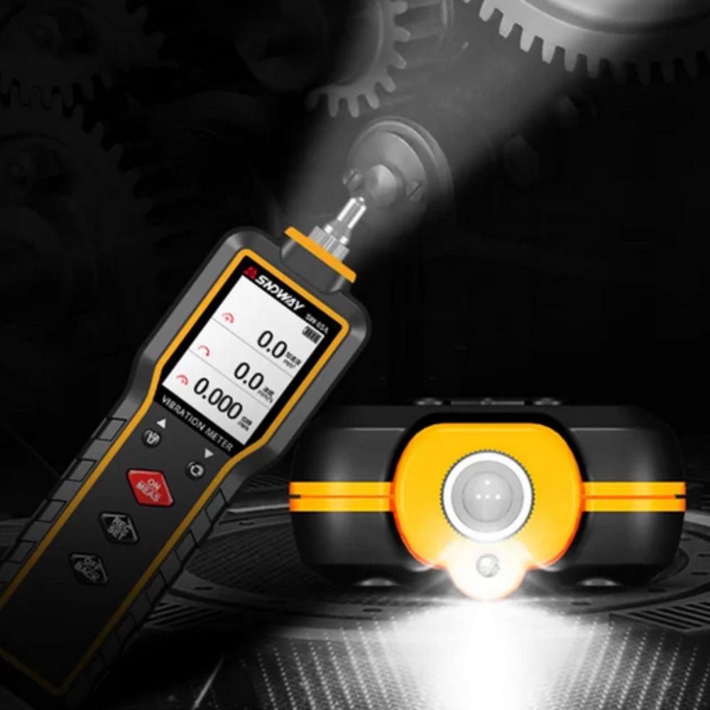 The SNDWAY SW-65A portable vibration tester featuring its built-in LED torch, illuminating a dark industrial environment during a machine inspection.