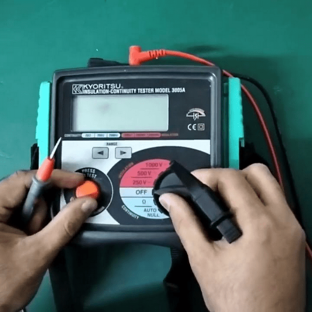 A technician preparing to perform an insulation resistance measurement with the KYORITSU 3005A tester, with test leads connected and ready.