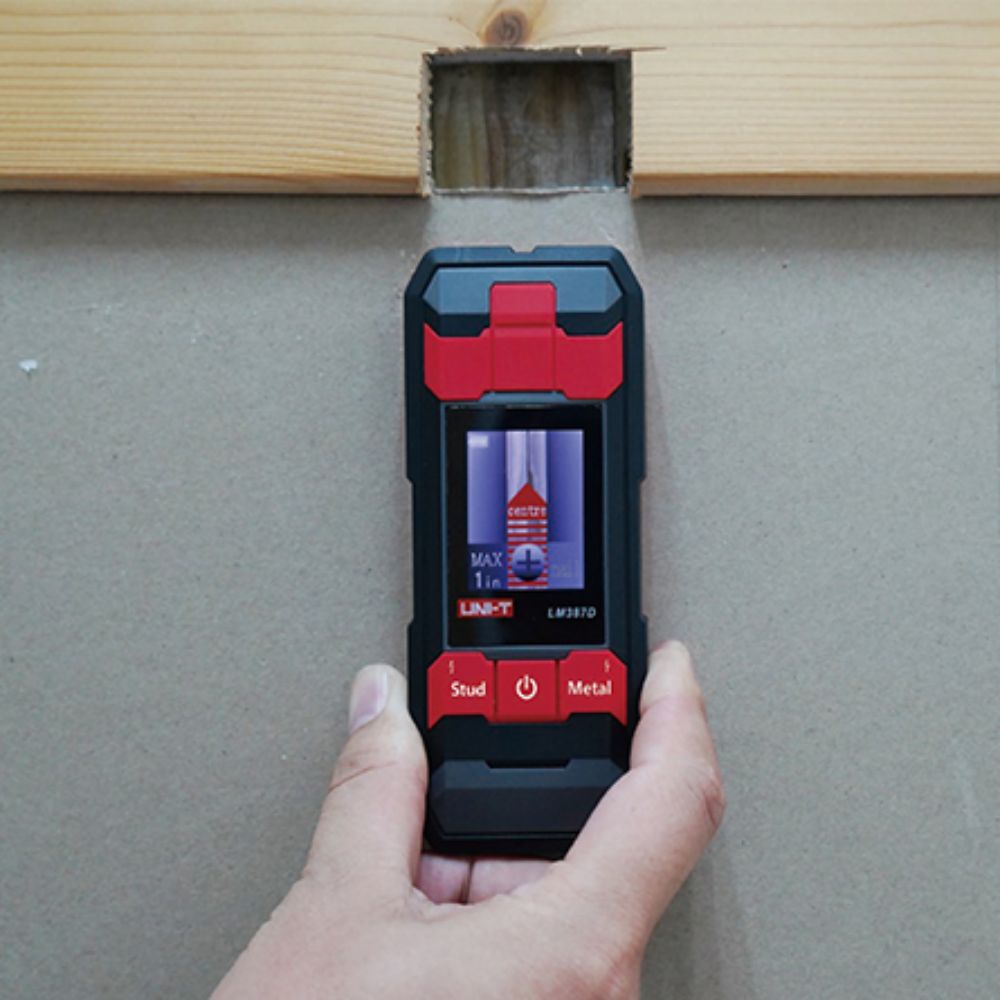 Professional technician using the UNI-T UT387D voice alert wall scanner to safely detect hidden copper pipes and live wires in concrete.