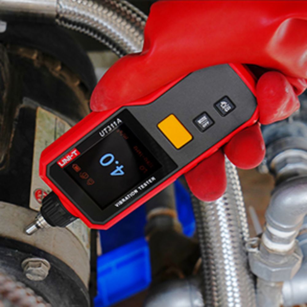 Mechanic using the UNI-T UT311A portable vibration tester to measure engine vibration and diagnose mechanical unbalance on an automobile.