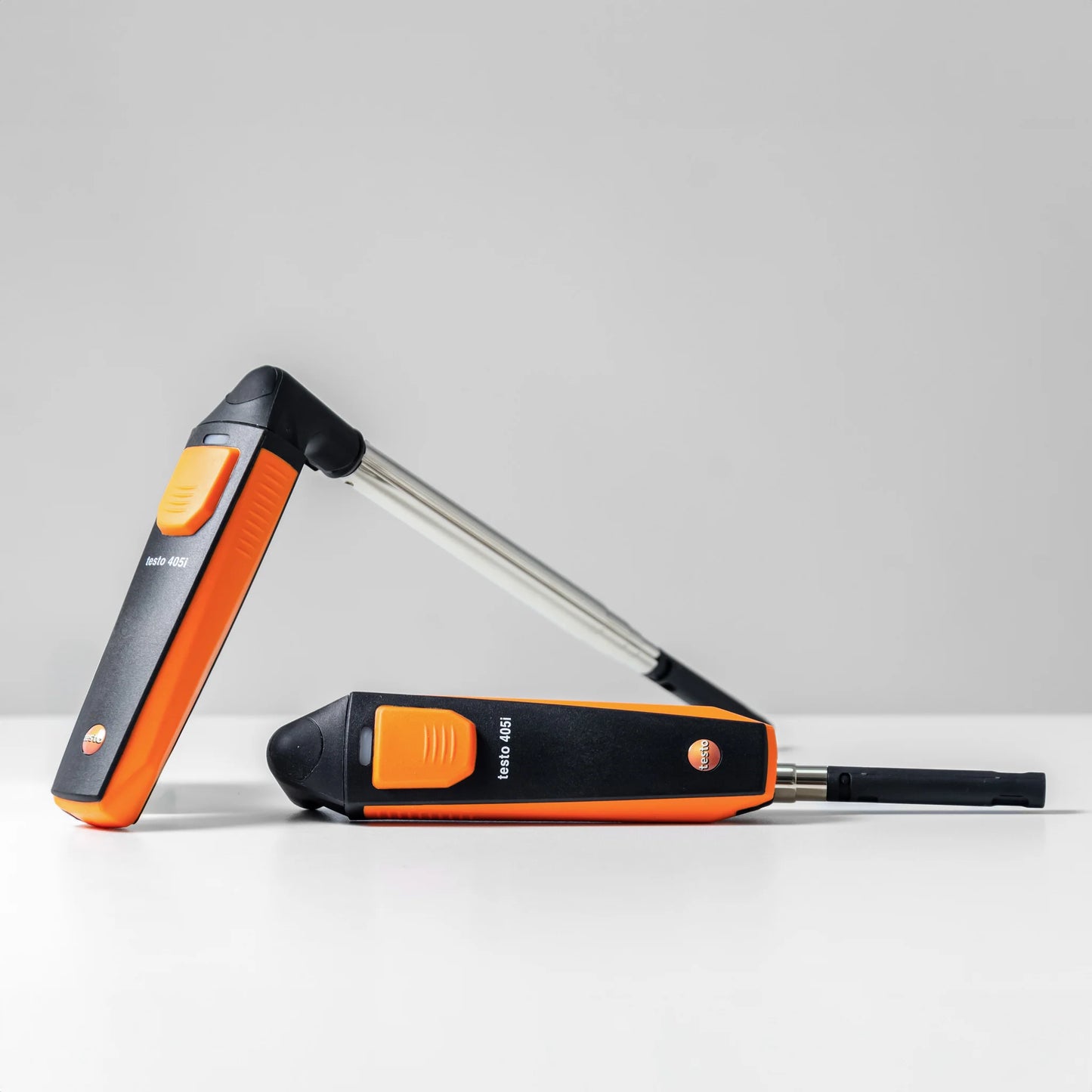 Two testo 405i hot-wire anemometers showcasing the flexible pivoting probe head, with one bent at a 90-degree angle for versatile positioning.