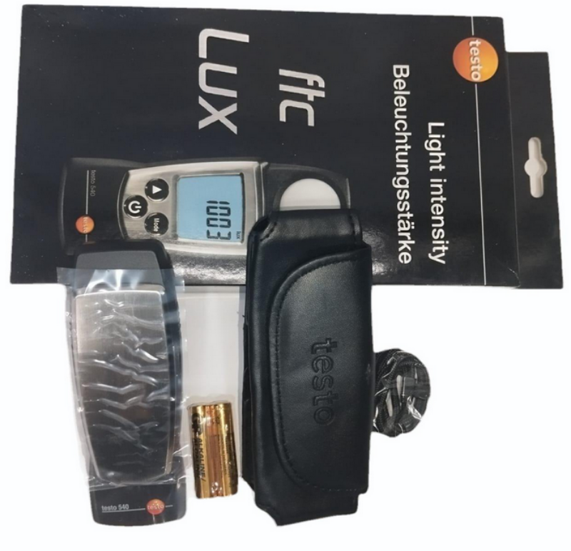 Full package contents for the TESTO 540 light meter, showing the device, protective cap, wrist strap, calibration protocol, and batteries.