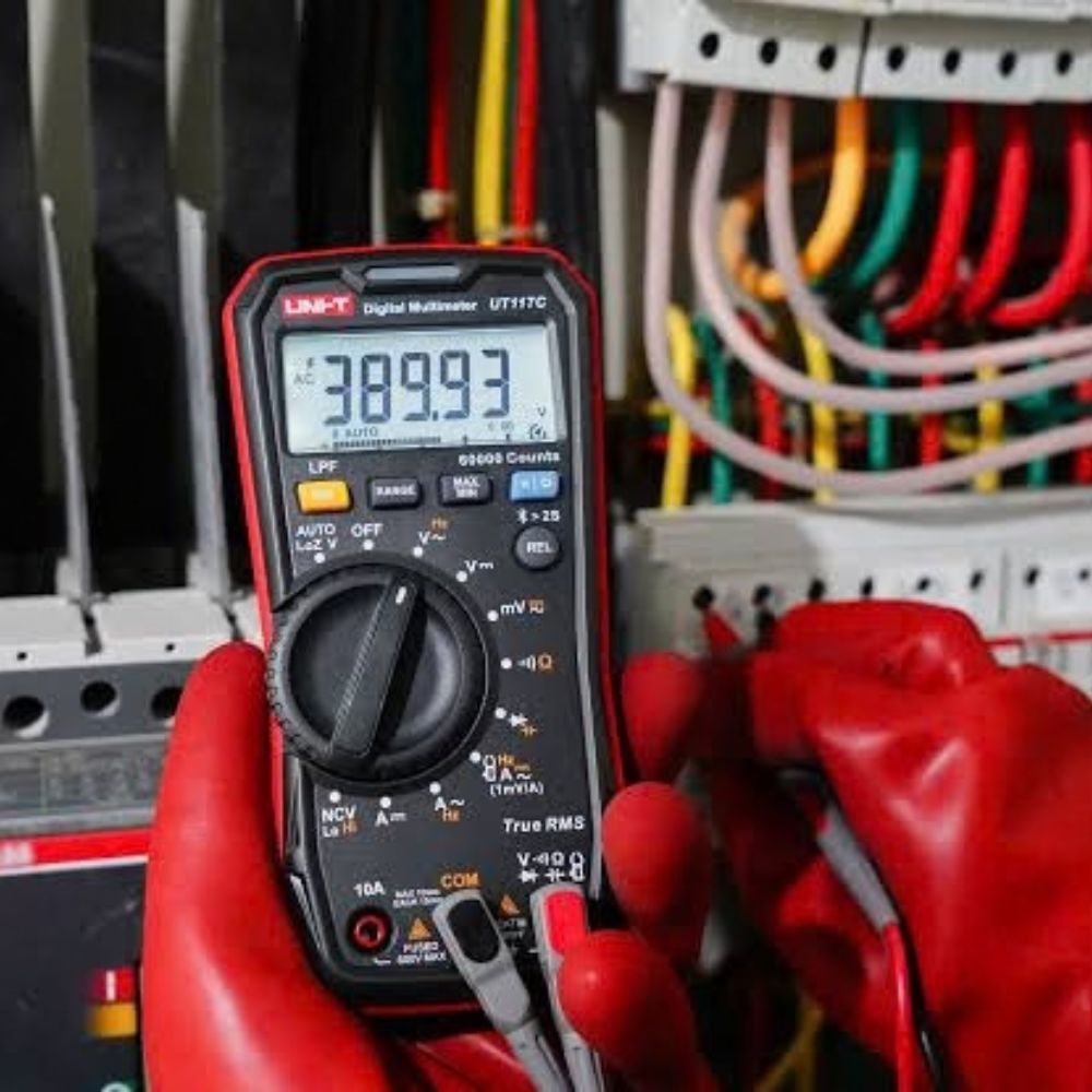 UNI-T UT117C digital multimeter measuring voltage on an industrial distribution board