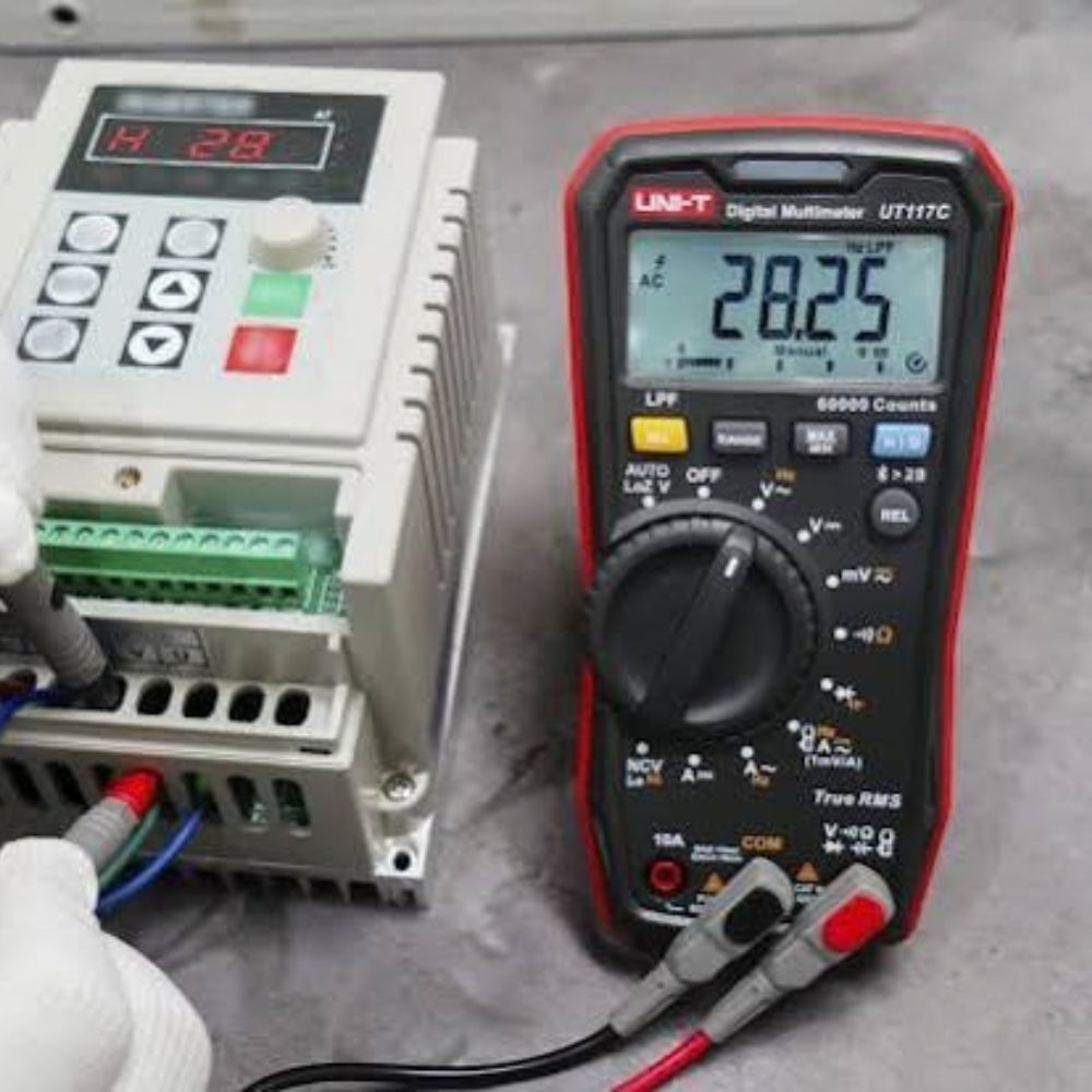 UNI-T UT117C multimeter testing an industrial timer switch for continuity and voltage