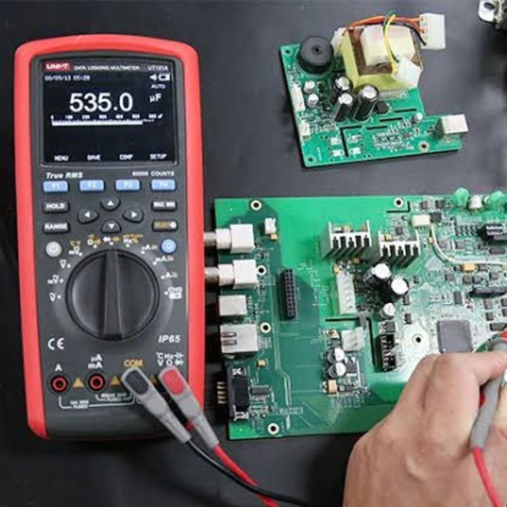 UNI-T UT181A multimeter testing an industrial automation circuit board for voltage and continuity
