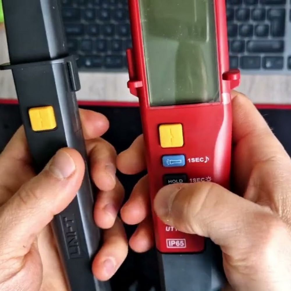 Technician holding the UNI-T UT18D LCD voltage tester in hand, with probes prepared to perform a precise digital continuity and electrical safety test.
