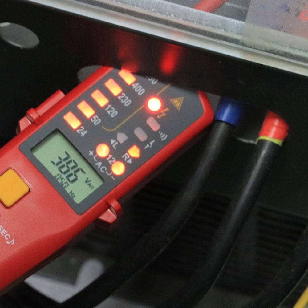 The UNI-T UT18E high voltage continuity tester safely measuring electrical current and checking for faults on an industrial 3-phase power supply panel.
