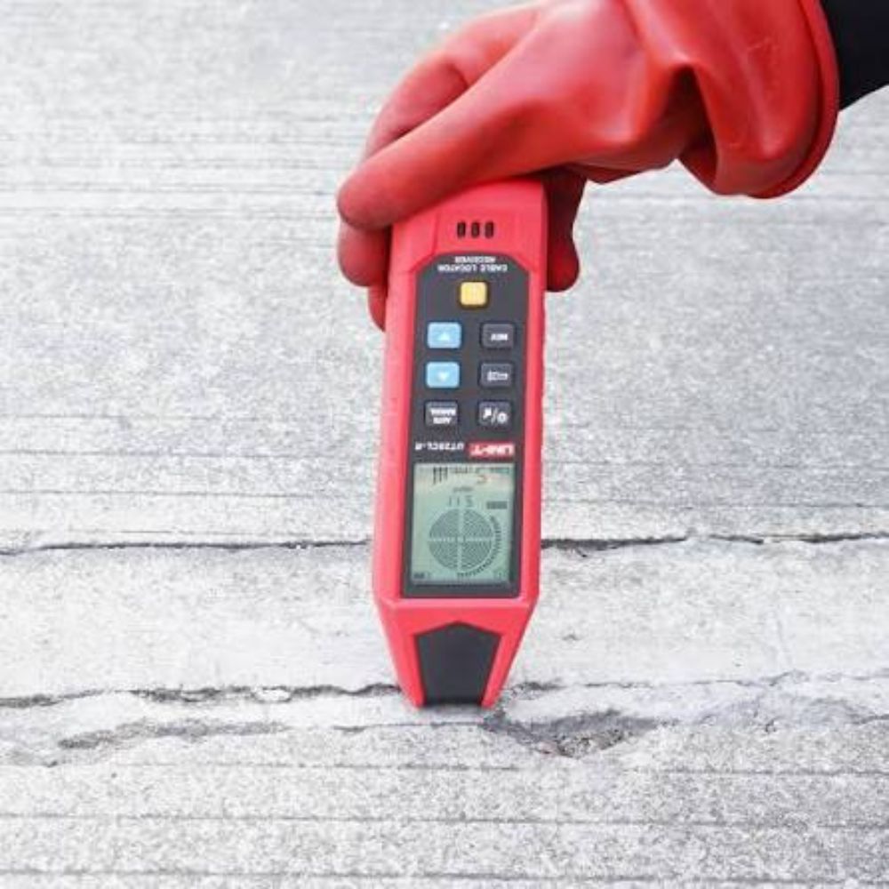 UNI-T UT25CL underground cable locator in use tracing a buried wire with transducer probe