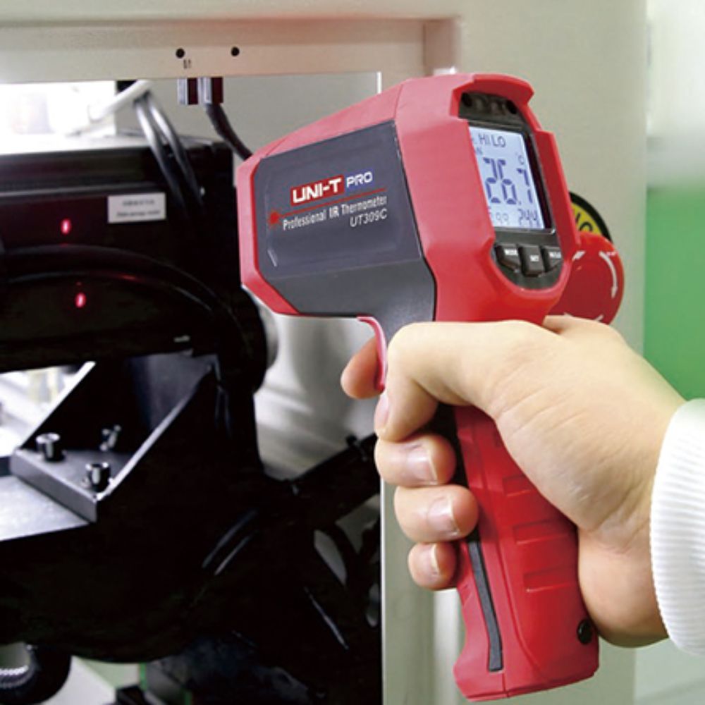 UNI-T UT309C industrial infrared thermometer measuring pneumatic system surface temperature in a workshop environment