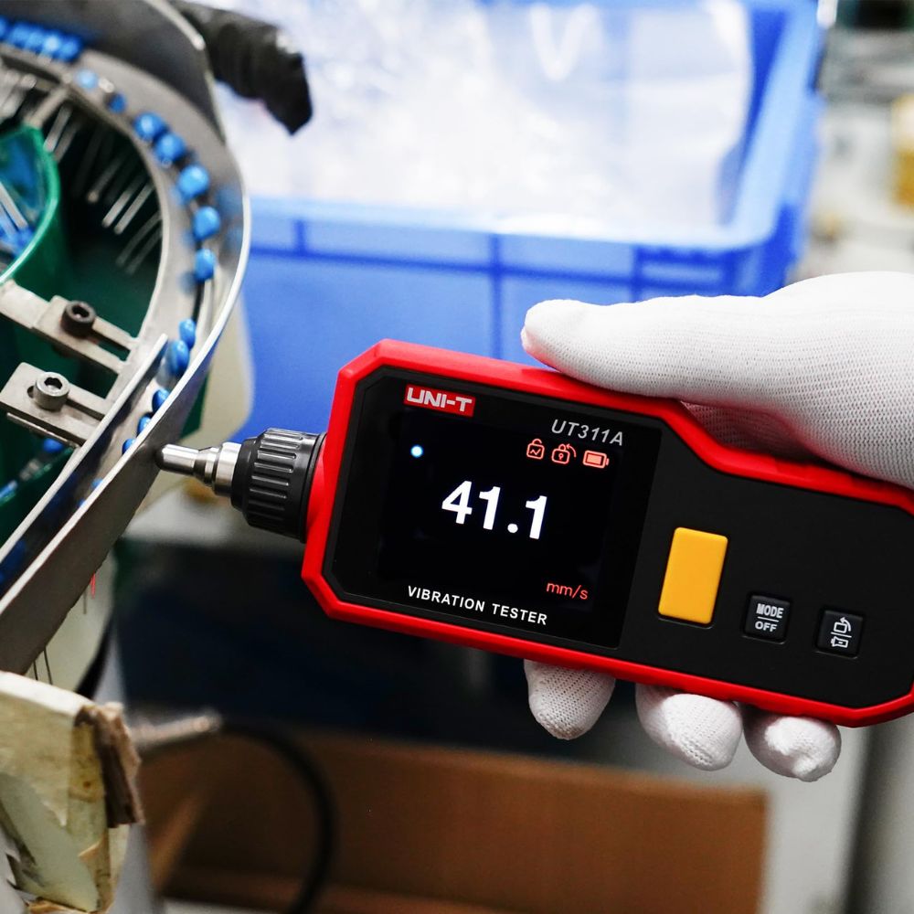Maintenance engineer performing a routine machinery vibration inspection on the factory floor using the compact UNI-T UT311A digital vibration meter.