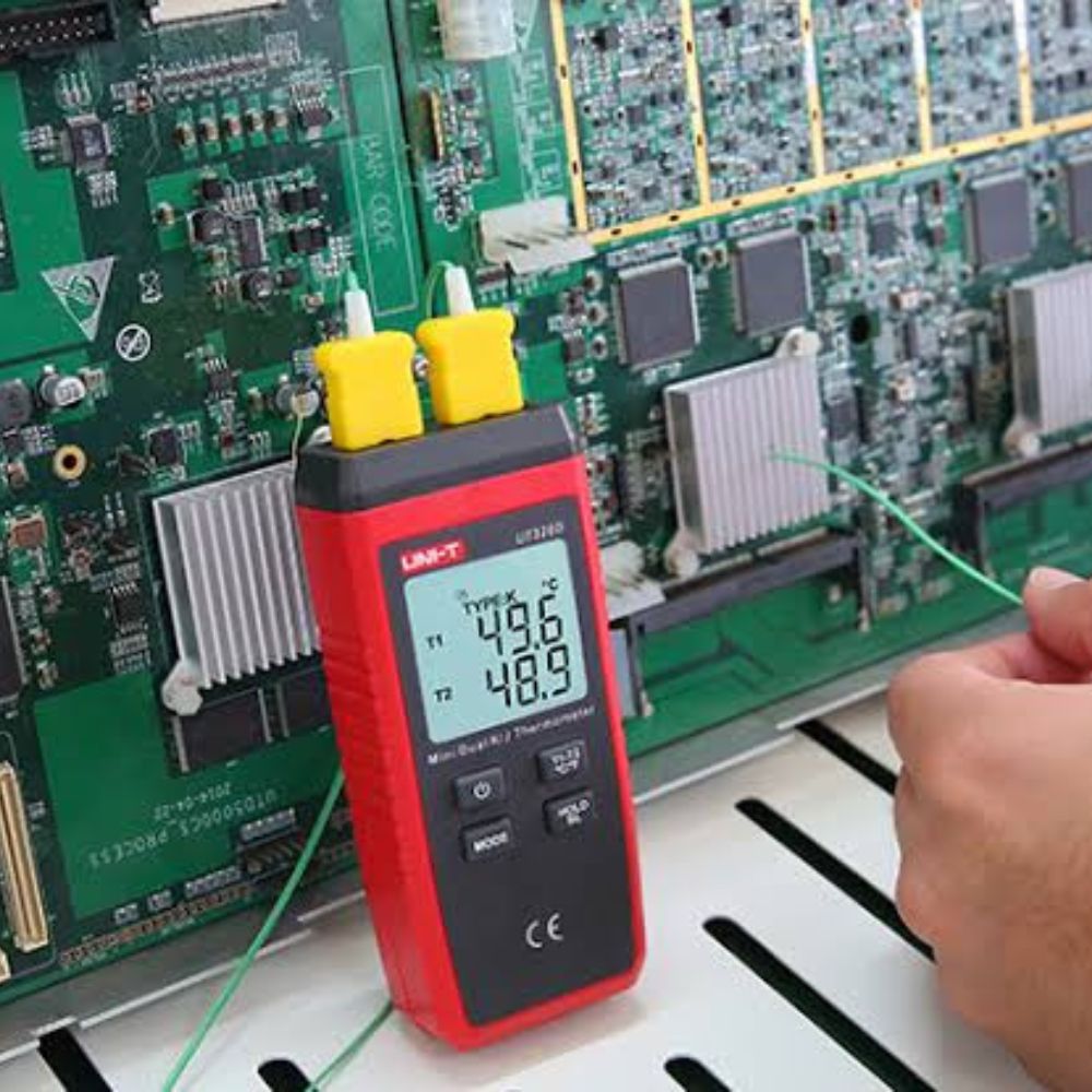 UNI-T UT320D thermocouple thermometer measuring the temperature of circuit components with a K-type probe