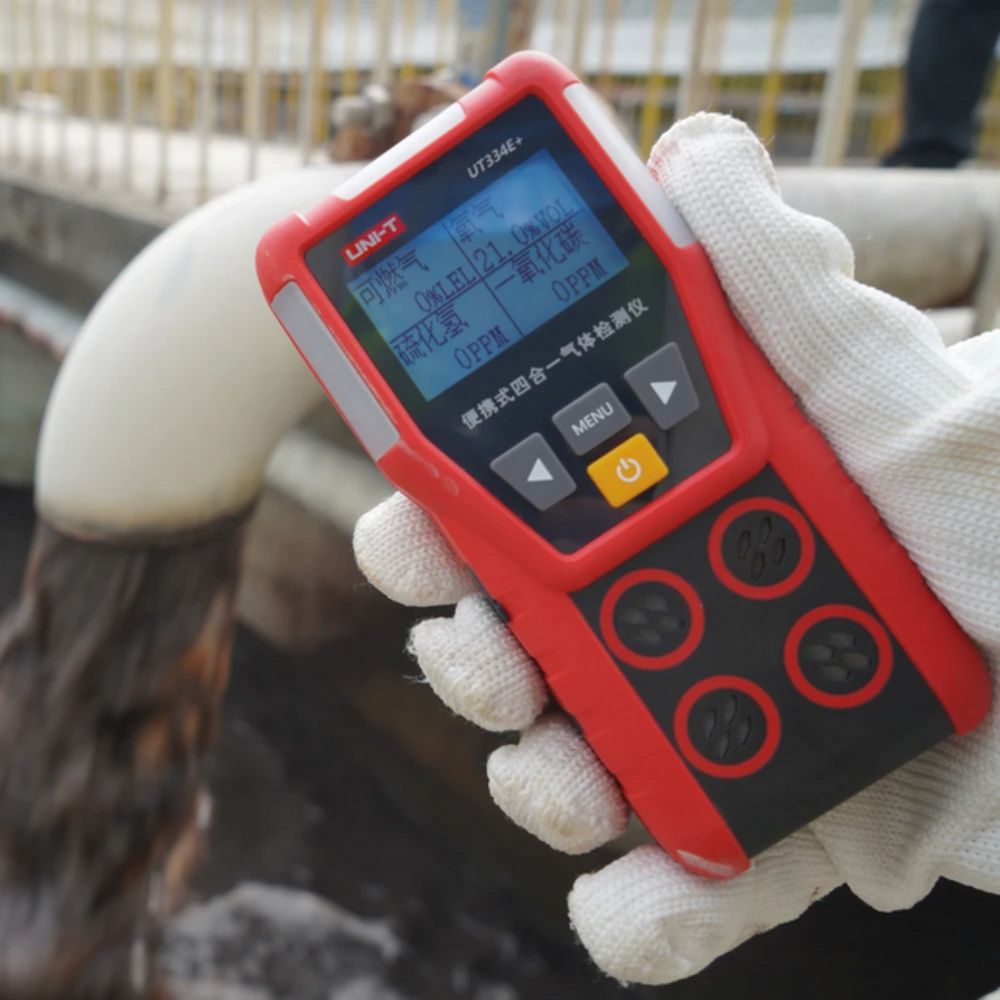 Safety technician holding UNI-T UT334E+ 4 Gas Monitor in palm checking 21.0% O2 levels - portable multi gas detector for real-time hazardous gas detection in industrial workplaces