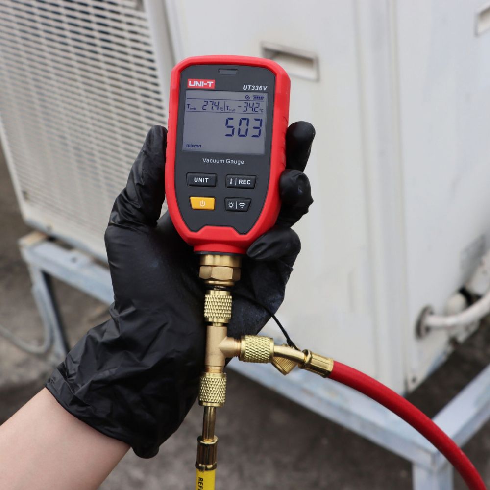 UNI-T UT336V Wireless Vacuum Gauge performing vacuum testing on an air conditioning outdoor unit