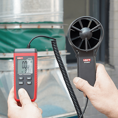 Measuring air velocity from a large industrial air duct with the UNI-T UT363S digital anemometer, showing its practical use for ventilation system testing.