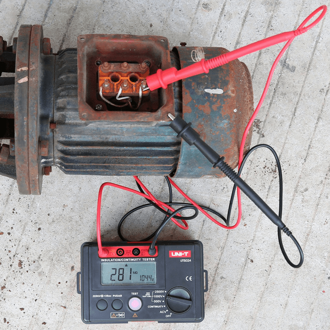 The UNI-T UT502A insulation resistance tester measuring insulation in a motor power supply box, with a 281 MΩ reading displayed.