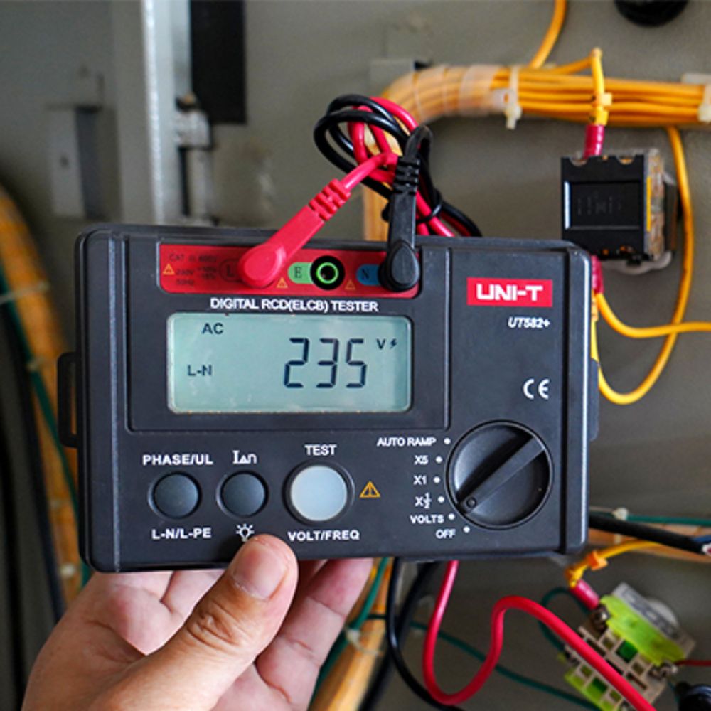 UNI-T UT582+ RCD ELCB Tester in use at an electrical distribution box — trip time ramp test
