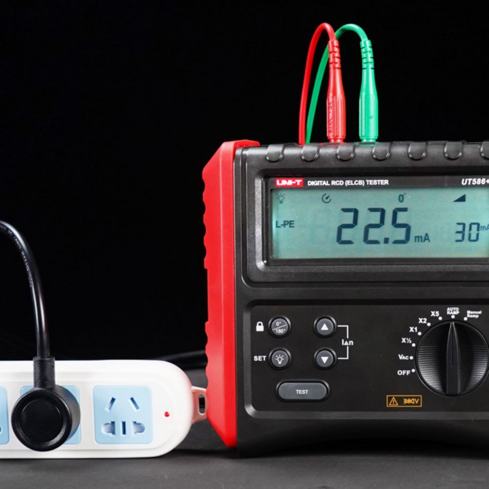 UNI-T UT586+ RCD loop impedance tester performing trip time test at a wall socket plug base