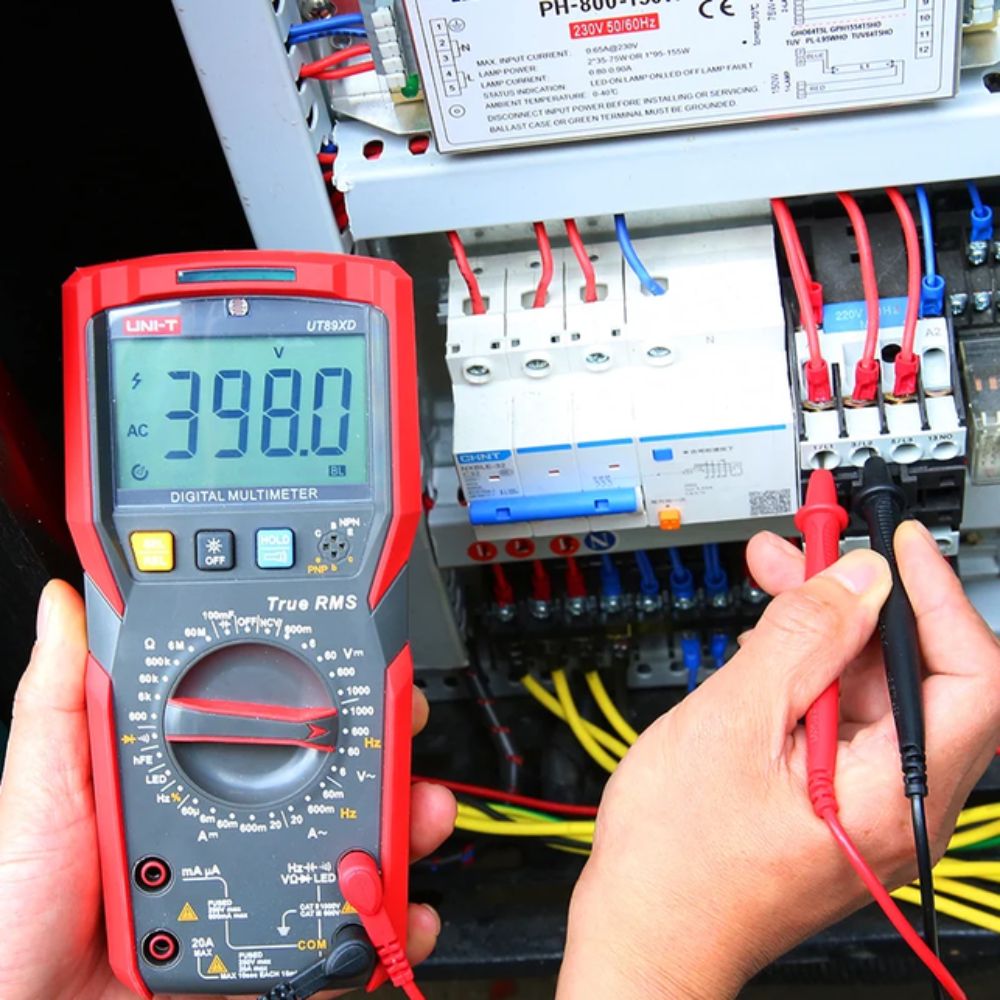UNI-T UT89XD Digital Multimeter testing voltage on a circuit breaker board