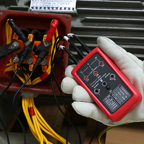 An electrician using the UNI-T UT261B as a motor rotation tester by connecting the alligator clips to a 3-phase motor's wiring.